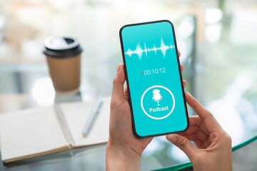 Woman hands holding smartphone and listening podcast with waveform application on mobile.