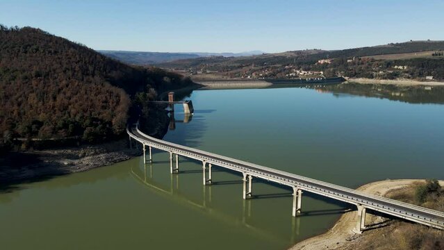 Aerial view of vehicles driving on the highway along Corbara lake (Lago di Corbara), Baschi, Terni, Italy.