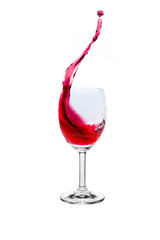 Red wine splash into glass on white background.