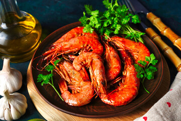 Red Langostino shrimps Prawns on a wooden board. Gray background. Top view. Copy space.