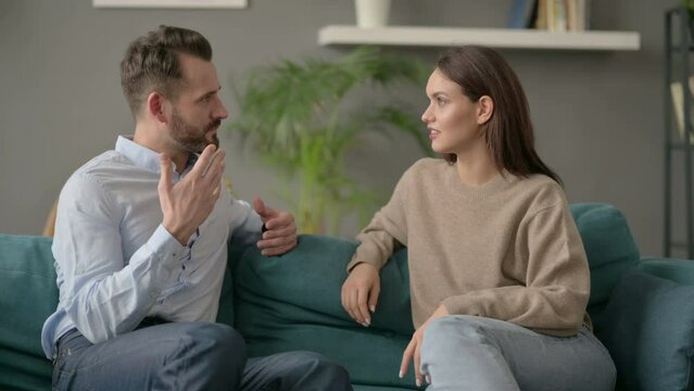 Man Talking to Woman while Sitting on Sofa 