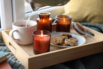 Obraz na płótnie Canvas Breakfast tray with burning candles near window indoors