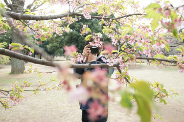 桜の花の写真を撮るカメラ男子