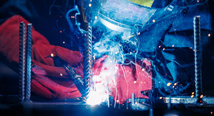 Professional welder erecting metal steel. Banner Factory industrial worker in workplace with spark