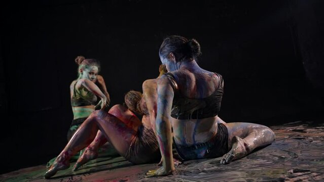 modern choreographic theater, young female dancers are dancing on floor with paints