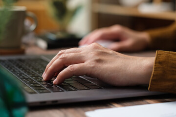 close up hand typing on laptop keyboard when woking at home