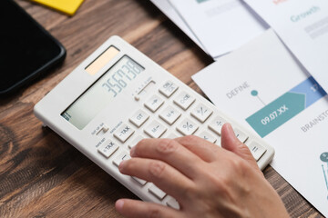 close up hand using calculator calculate tax and budget of project at home