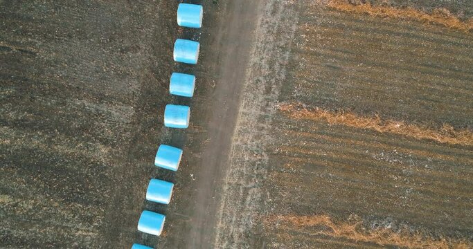 Kibbutz, Israel - 25 November 2021: Aerial view of a tractor loading cotton bales on truck, Kibbutz Saar, Mate Asher, Israel.
