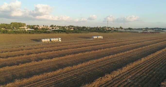 Kibbutz, Israel - 25 November 2021: Aerial view of lorries transporting cotton bales in a field, Kibbutz Saar, Mate Asher, Israel.