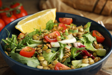 Delicious salad with lentils and vegetables on table, closeup