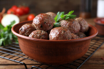 Tasty cooked meatballs with parsley on wooden table, closeup