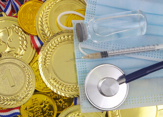 Face mask with stethoscope, vaccine and syringe on gold medals background. Vaccination, health care...