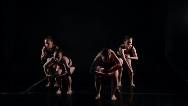 contemporary dance performance on theatrical stage, four women are dancing together
