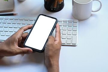 Close up view businessman using smart phone at office desk.