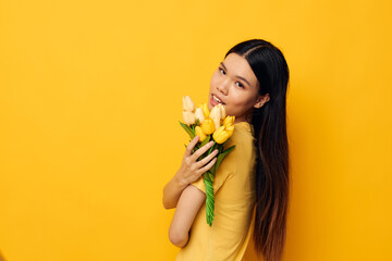 woman with Asian appearance bouquet of flowers in hands spring fun posing studio model unaltered