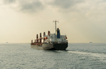 Obraz premium Ship cruising on the sea, in a partly cloudy day. Rear view .