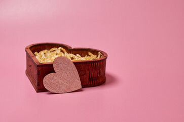 Wooden gift box in the shape of a heart and a cardboard heart