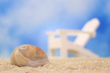Fototapeta na wymiar Sea Shell and Beach Chair on beach, Shallow DOF, Focus on Shell