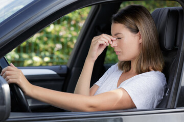Obraz na płótnie Canvas stressed woman having headache while driving car