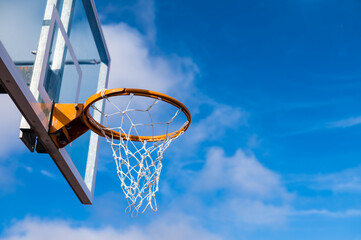 Low angle view of basketball hoop against blue sky - Powered by Adobe
