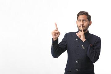 young indian man in traditional wear and giving expression on white background.