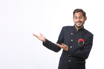 young indian man in traditional wear and giving expression on white background.
