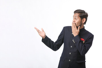 young indian man in traditional wear and giving expression on white background.