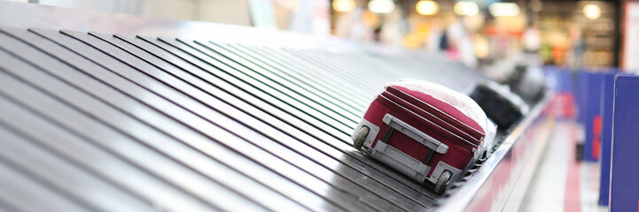 Packed suitcase on rubber band at airport closeup