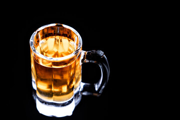 glass mug with beer without foam on a black background. low-alcohol drink. brewery. soft drink.
