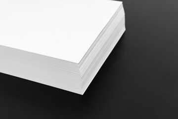 a stack angle of sheets of white paper on a black background. paper for letters, copies and printing. sale of stationery. economy, recycling and reuse.