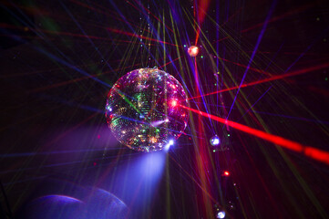 Mirrored Disco Ball and bright beams at the night party. Party attribute reflects Lazer lights....