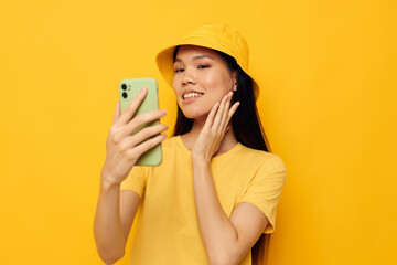 Portrait Asian beautiful young woman in a yellow hat and T-shirt talking on the phone Lifestyle unaltered