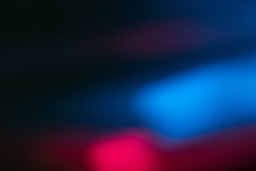 Neon blur glow. Color light overlay. Disco illumination. Defocused blue pink red ultraviolet radiance soft texture on dark black abstract empty space background.