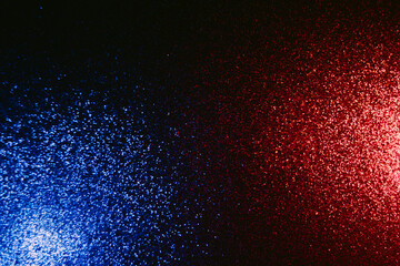 Color light background. Blur glitter glow. Glitz decoration. Defocused blue red shimmering sparkles pattern on dark black abstract overlay.