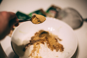 Cooking cookies at home for the new year and Christmas. a woman puts a spoonful of seasonings in flour