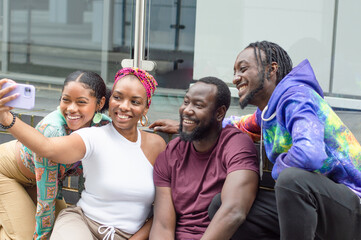 Group of smiling friends taking selfie outdoors
