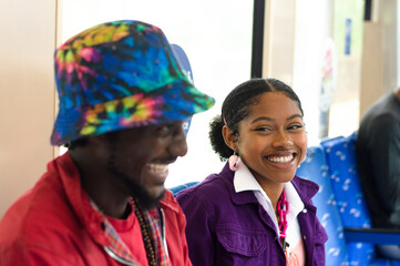 Smiling friends sitting in subway train