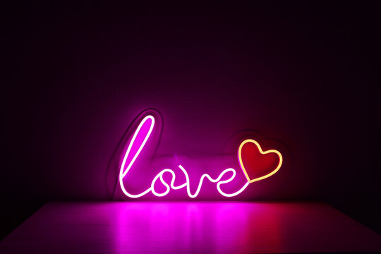 Pink and red neon heart with the inscription love. Valentine day. Neon sign. Custom neon. Home decor. Trendy style. Wedding design.