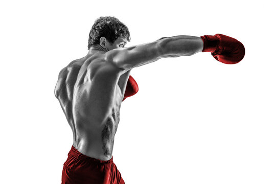 Side view of boxer in red gloves who practicing swing on white background. Black and white
