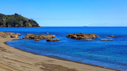 Beach at Omaio in the eastern Bay of Plenty, New Zealand. On the horizon is White Island, a volcano