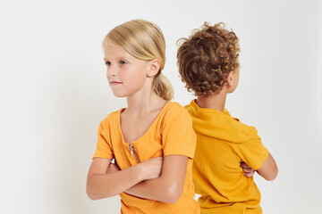picture of positive boy and girl in yellow t-shirts standing side by side childhood emotions unaltered