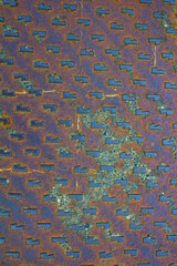evocative image of a rusty metal plate with regular shapes 
