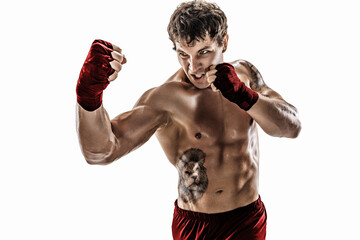 Portrait of aggressive boxer who training, practicing uppercut on white background. Red sportswear
