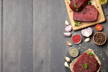 Obraz na płótnie Canvas Concept of tasty food with raw beef steaks on dark wooden background