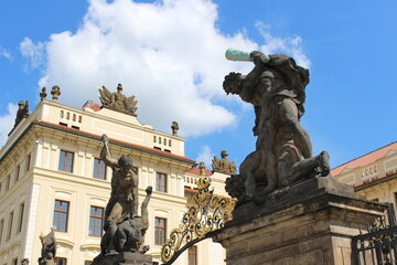 Fototapeta na wymiar Prague Castle main gate statue, detail, in summer with white clouds
