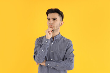Fototapeta premium Attractive guy in shirt on yellow background