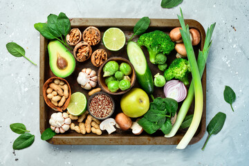 Vegetables, fruits, nuts and mushrooms on a metal tray. Healthy food. On a gray stone background. Top view.