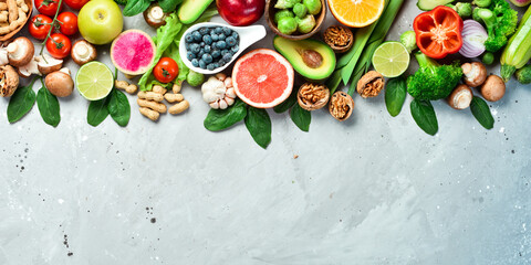 Healthy foods low in carbohydrates. Fresh broccoli, avocado, nuts, tomatoes and citrus fruits. The concept of a ketogenic diet. On a gray stone background. Top view.