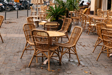Quarantine.Empty wooden tables and chairs on street outside a cafe bar or restaurant. The concept of love and romantic dinner