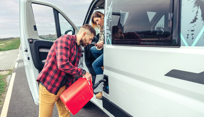 Man refueling his camper van with a jerrycan - obrazy, fototapety, plakaty